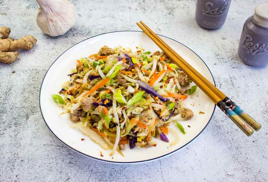 Egg Roll in a Bowl on a plate with chopsticks on the side.