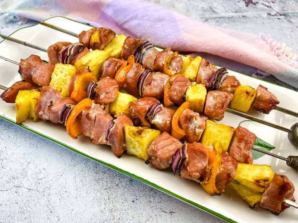 Smoked Pork & Pineapple Kabobs on a plate for serving.