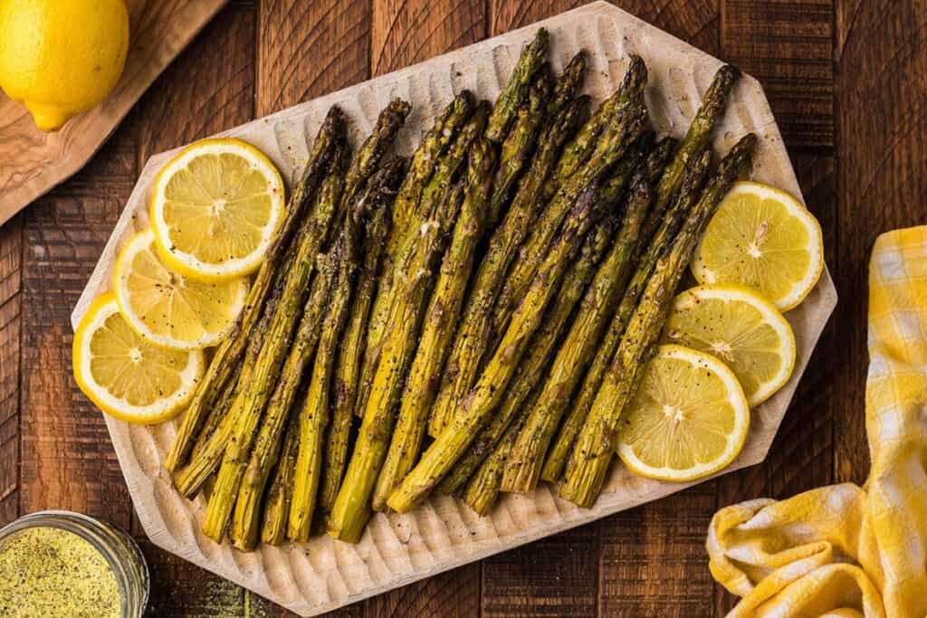 Smoked Asparagus on a platter with lemon slices.