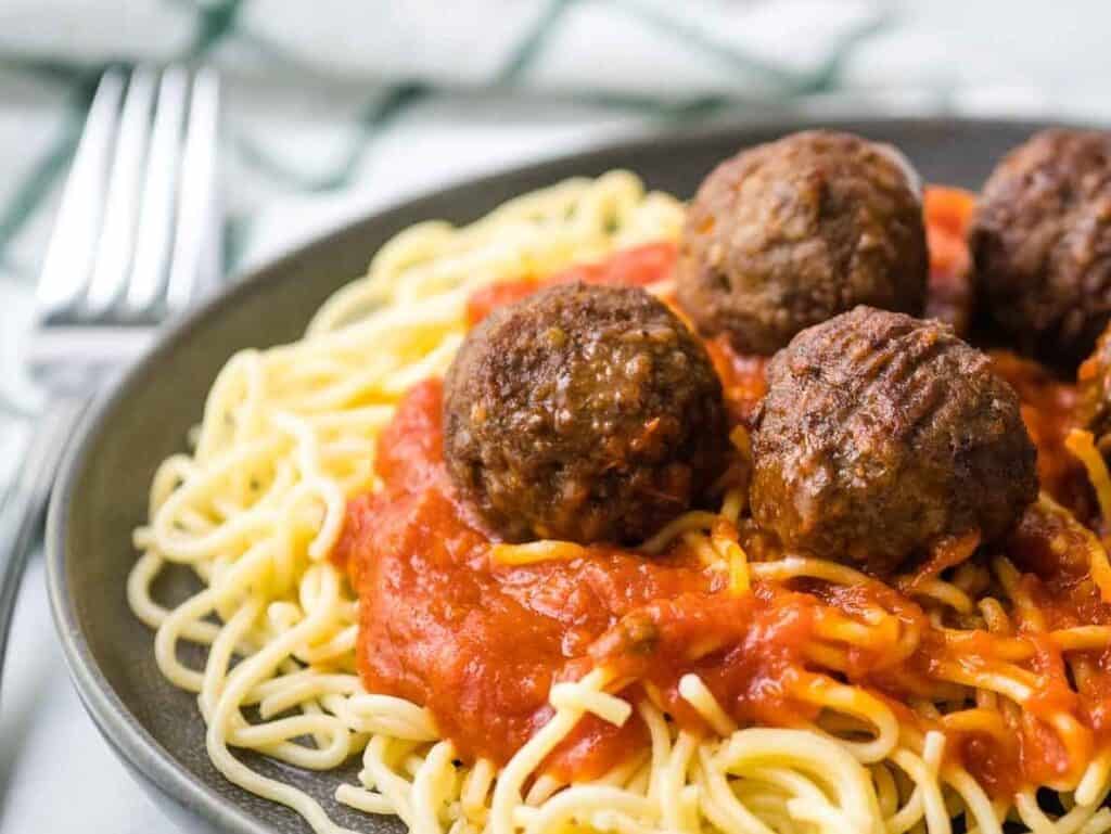 Air Fryer Frozen  Meatballs with sauce on top of spaghetti.