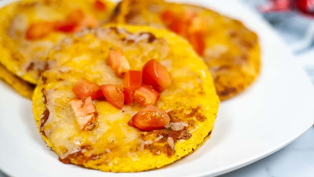 Copycat recipe: Cheesy corn tortillas with tomatoes and cheese on a plate.
