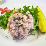 Ham Salad with dill pickle on a plate.