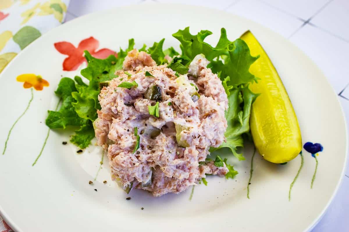 Ham Salad with dill pickle on a plate.