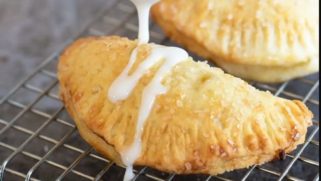 drizzling Air Fryer Hand Pies with icing.