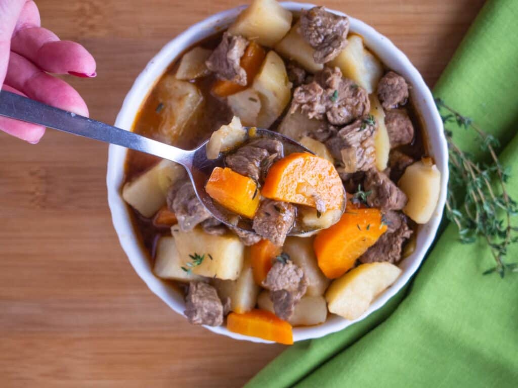 Lamb stew made in the Instant Pot in a bowl with a spoon.
