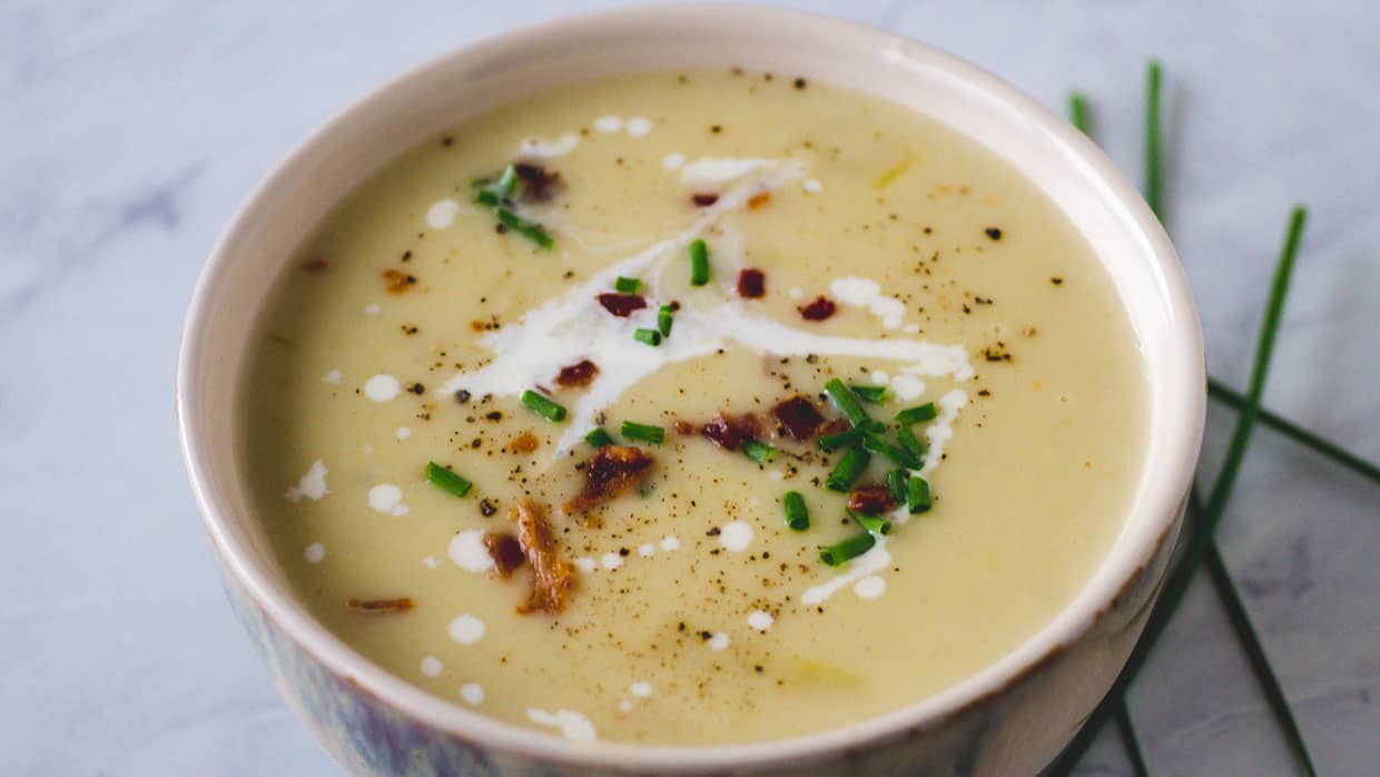Bowl of potato soup with bacon and chives.