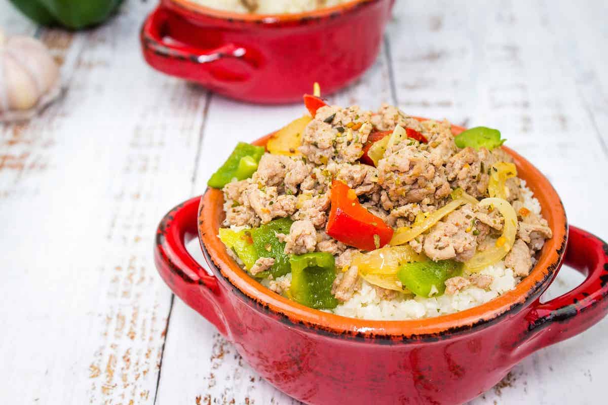 Italian turkey and peppers in a red bowl.