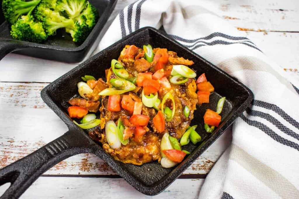 Chicken dish with vegetables in a square pot.