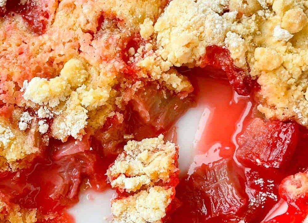 Magic Rhubarb Cake in a baking dish with a scoop out of it.