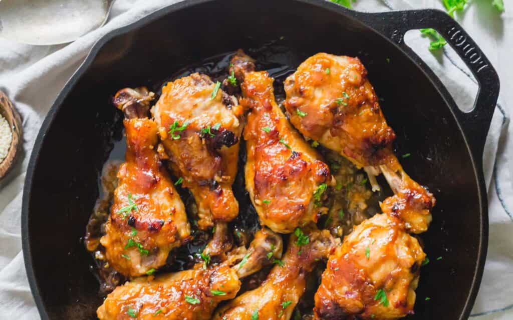 Maple miso chicken drumsticks in a cast iron skillet.