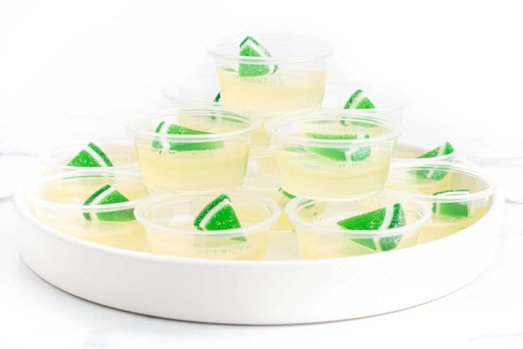 Jello shots in clear cups with a lime candy on top.