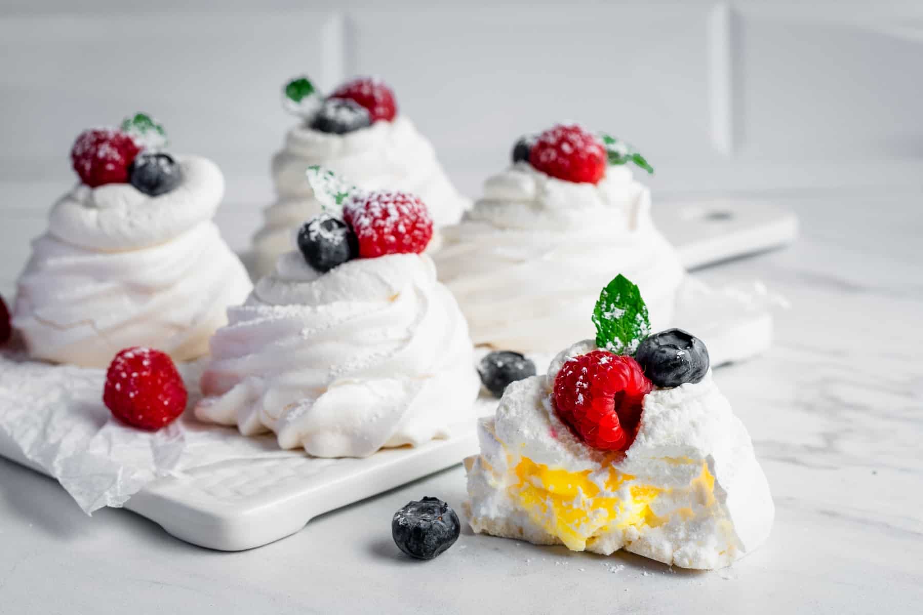 Mini pavlova filled with lemon curd and topped with berries.