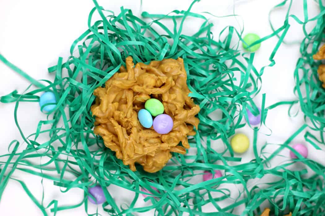 butterscotch chow mein cookies with M&M's in the center, to resemble birds nests with eggs in them, on top of faux grass.