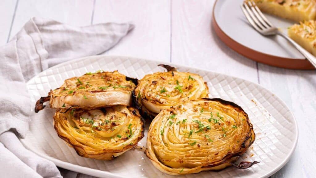 Roasted cabbage steaks on a platter.