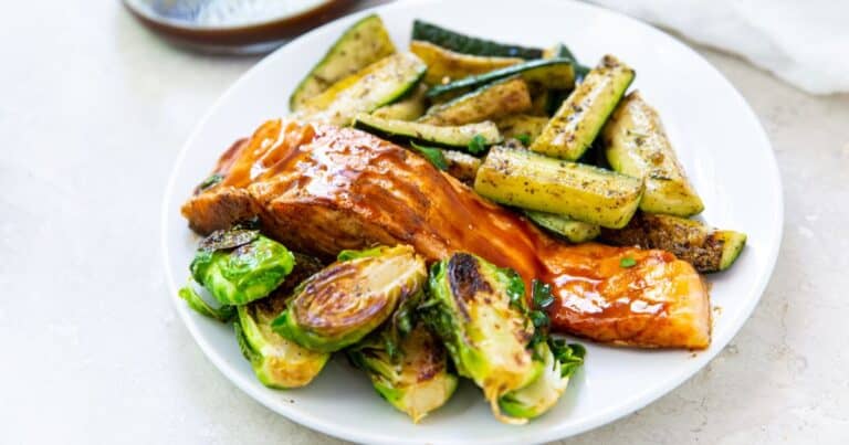 blackstone salmon, brussel sprouts and zucchini on a white plate