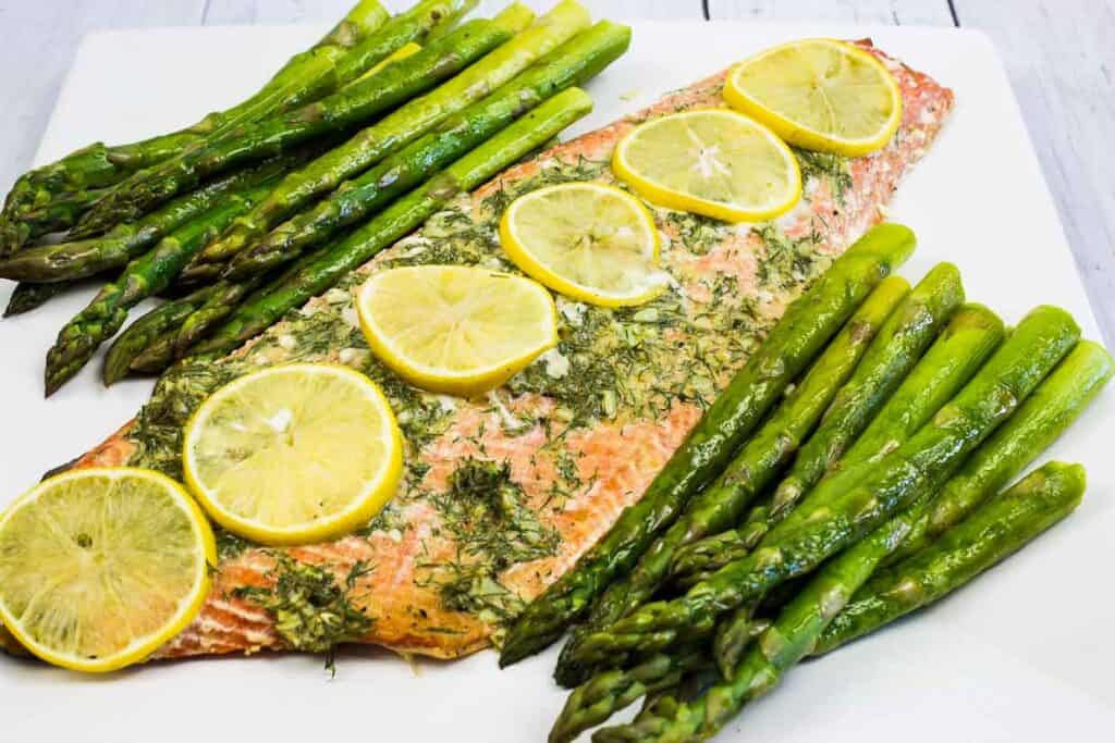 Salmon filet with asparagus and lemon slices.