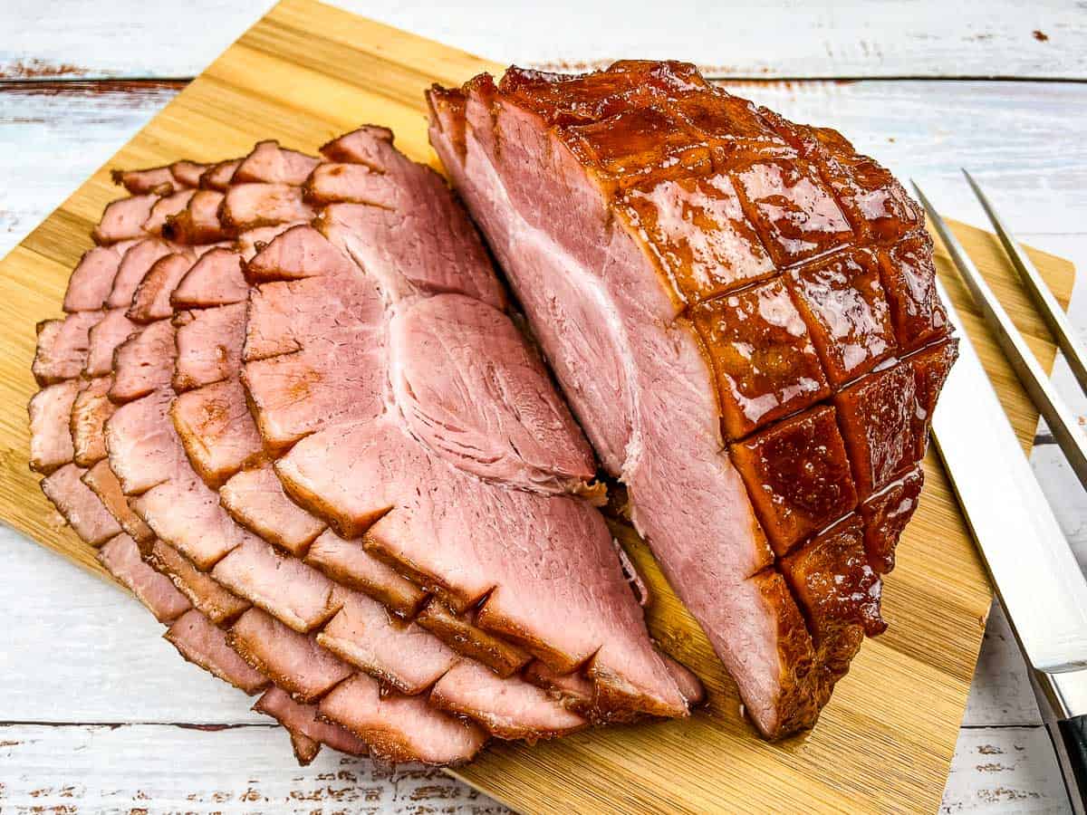 Smoked sliced ham on a cutting board.