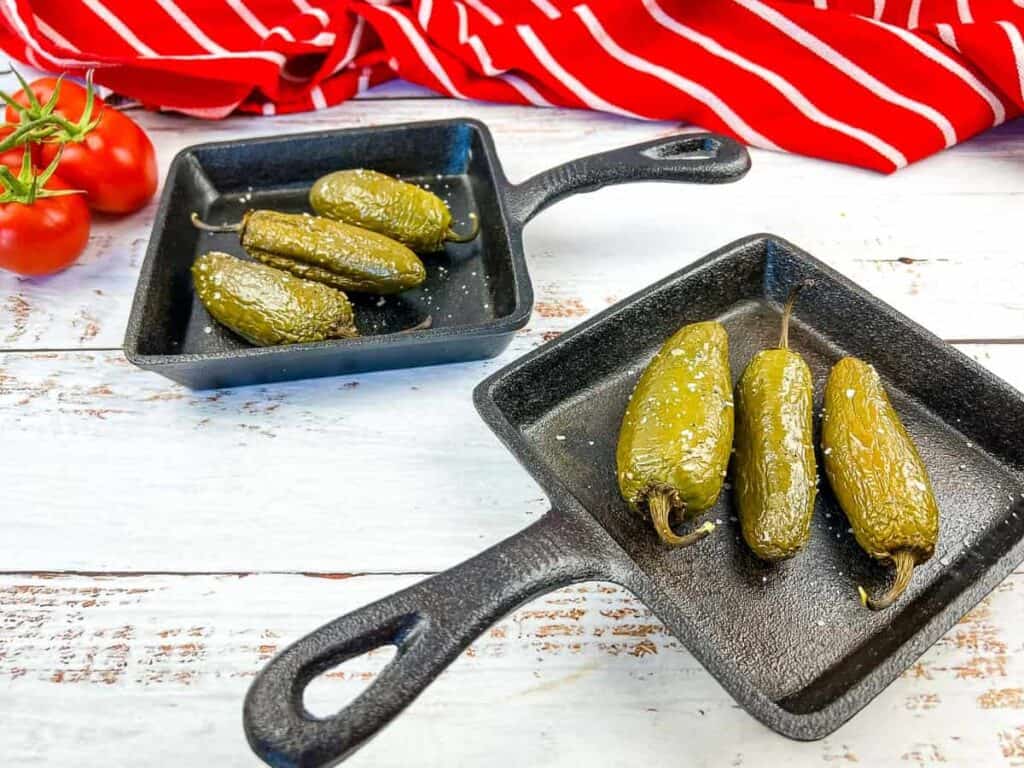 Smoked Jalapenos in 2 black dishes.