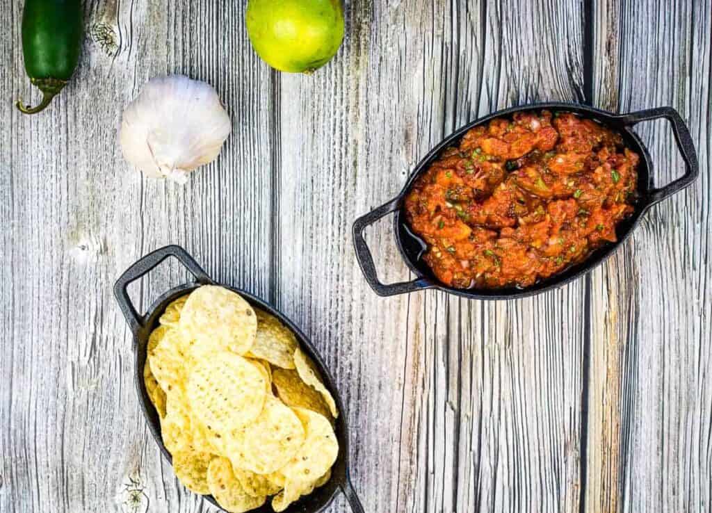 smoked tomato salsa and tortilla chips on a wooden table.