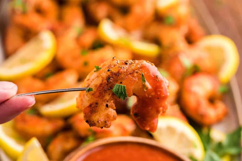 A smoked spicy shrimp on a pick to dip in sauce.