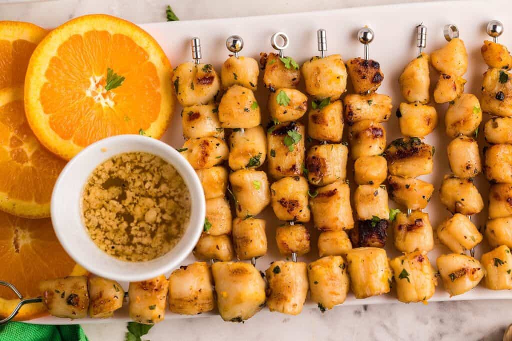 Grilled Scallop Skewers with orange and dipping sauce.