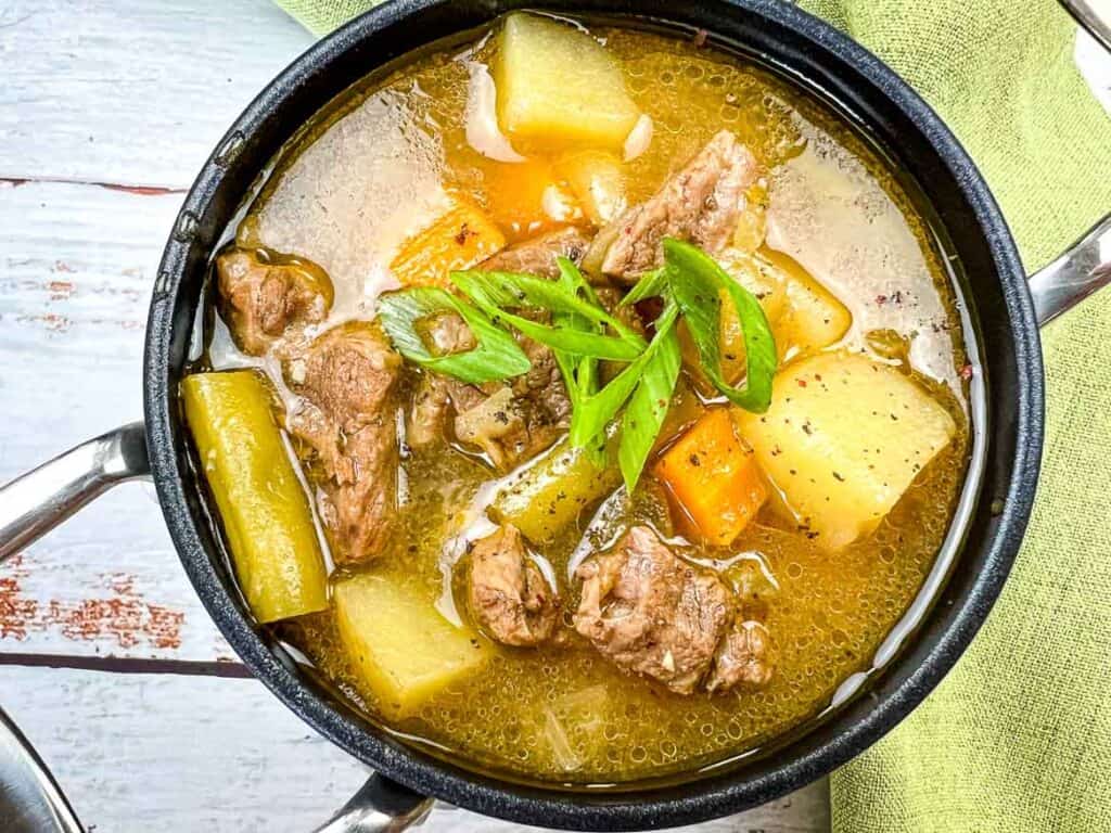 Steak and Potato Soup in a black bowl.