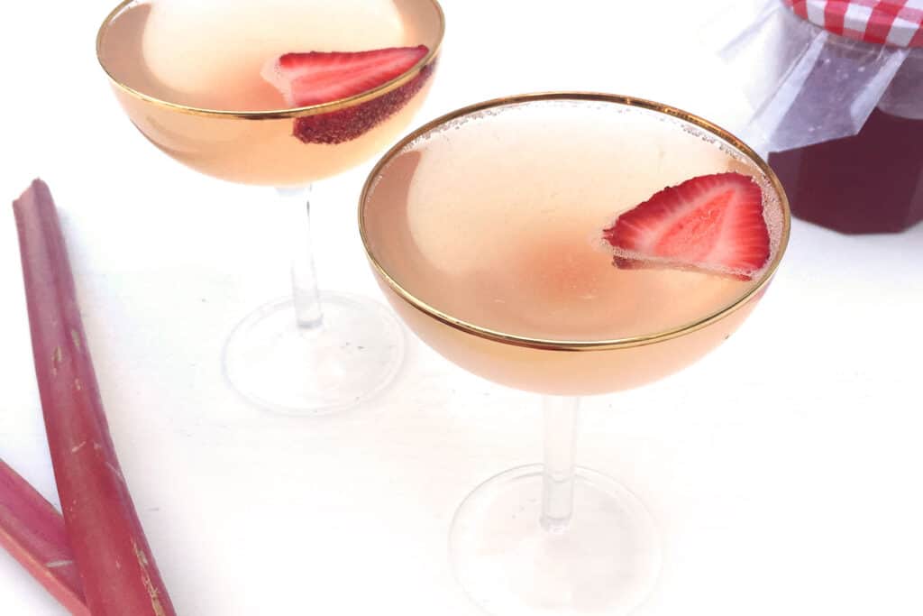 Strawberry Rhubarb Champagne in glasses with strawberries.