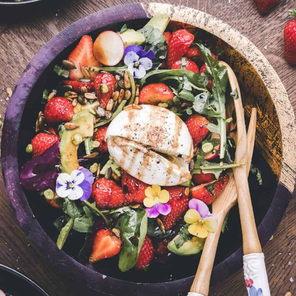 Strawberry salad in a wooden bowl.