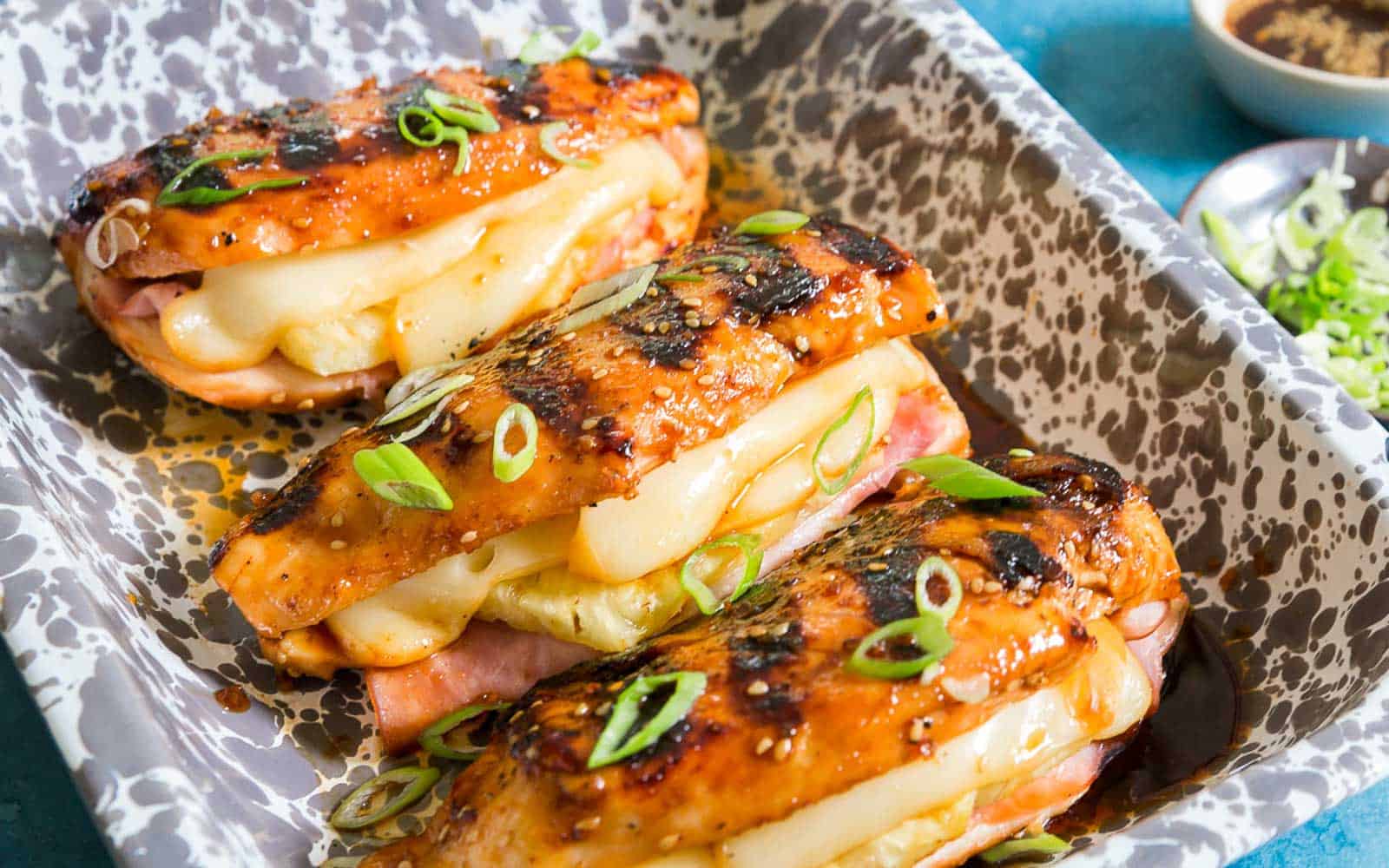 Grilled chicken breasts stuffed with ham, pineapple and Jarlsberg cheese garnished with green onion.