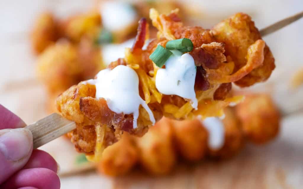Tater Tots on skewers with cheese and bacon added.