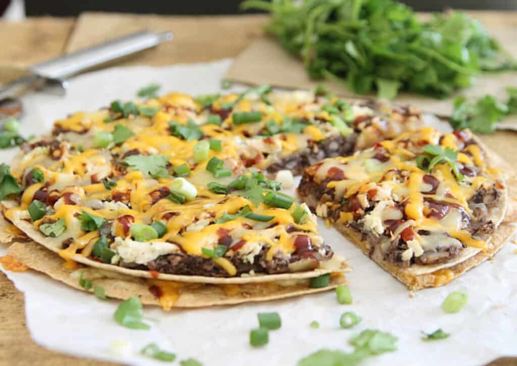 Tortilla pizza with black refried beans, cheddar and shredded chicken.
