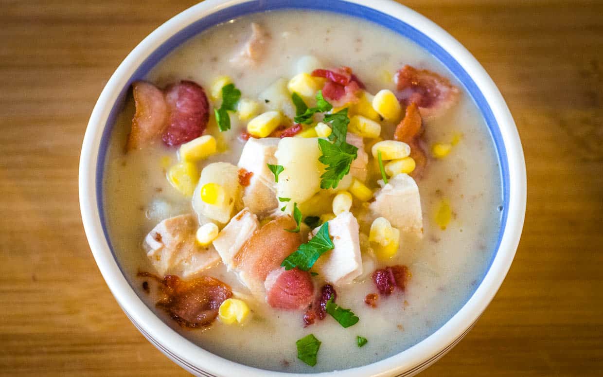 Bowl of turkey and corn chowder with bacon from the top.
