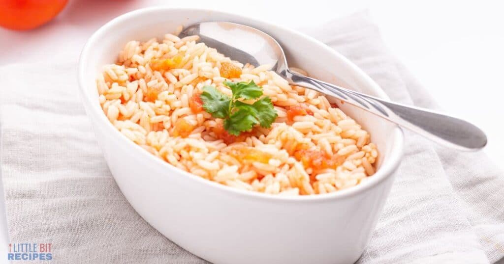 Mexican rice in small oval serving dish with spooon.