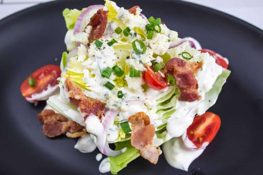 A wedge of lettuce topped with a creamy white sauce.