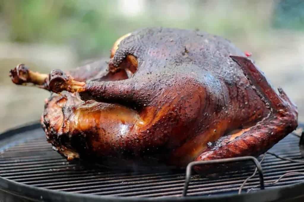 A whole smoked turkey on the grill.