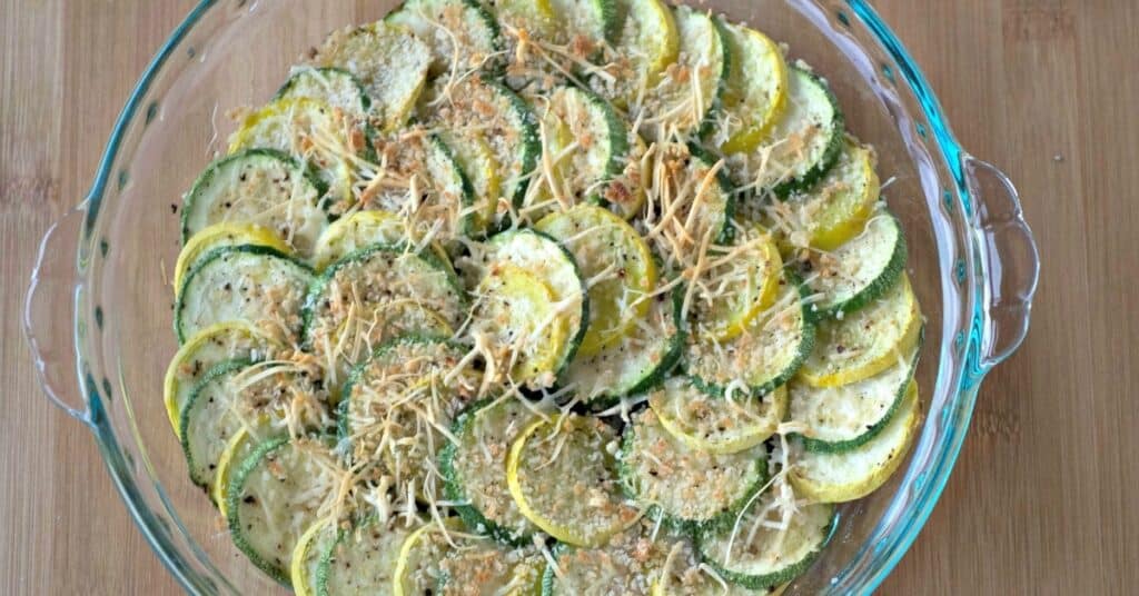 zucchini and summer squash alternated in a dish topped with breadcrumbs.