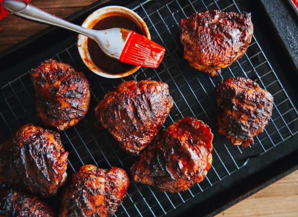 Chicken thighs on a baking sheet off the grill.