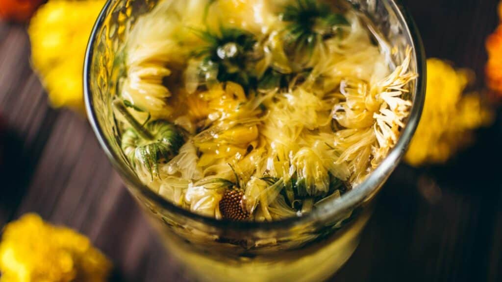 Close shot of clear glass filled with yellow flowers