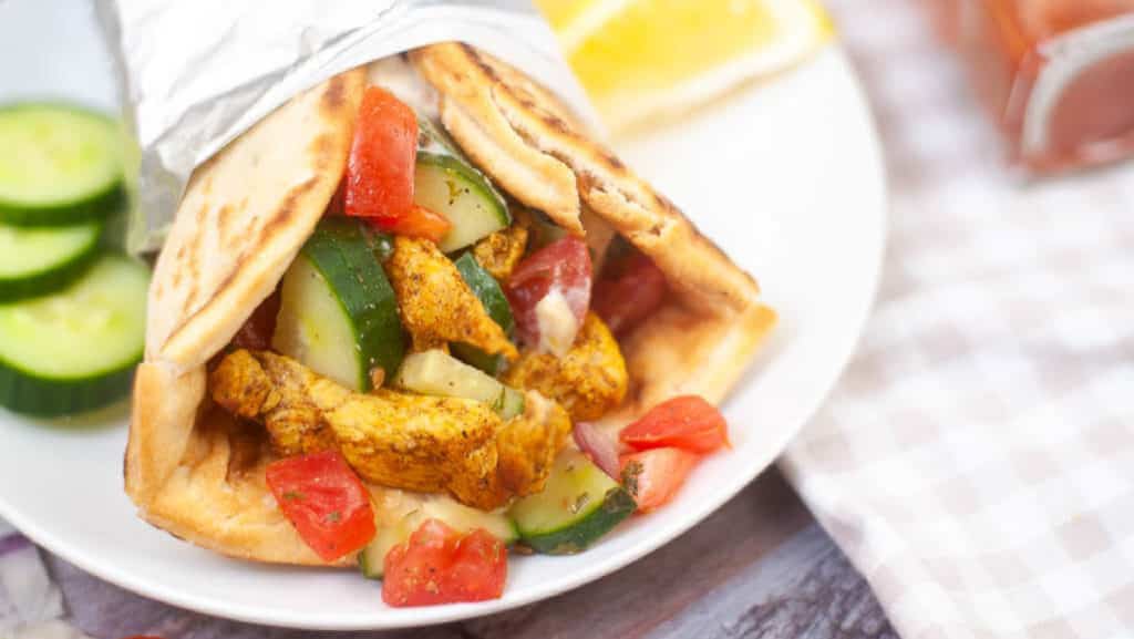 Chicken shawarma wrap with cucumbers and tomatoes.