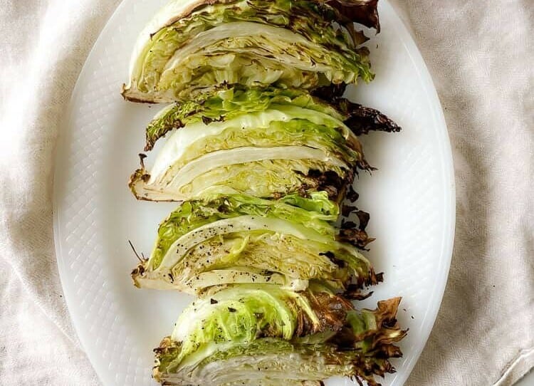 Sliced roasted cabbage on a white platter.
