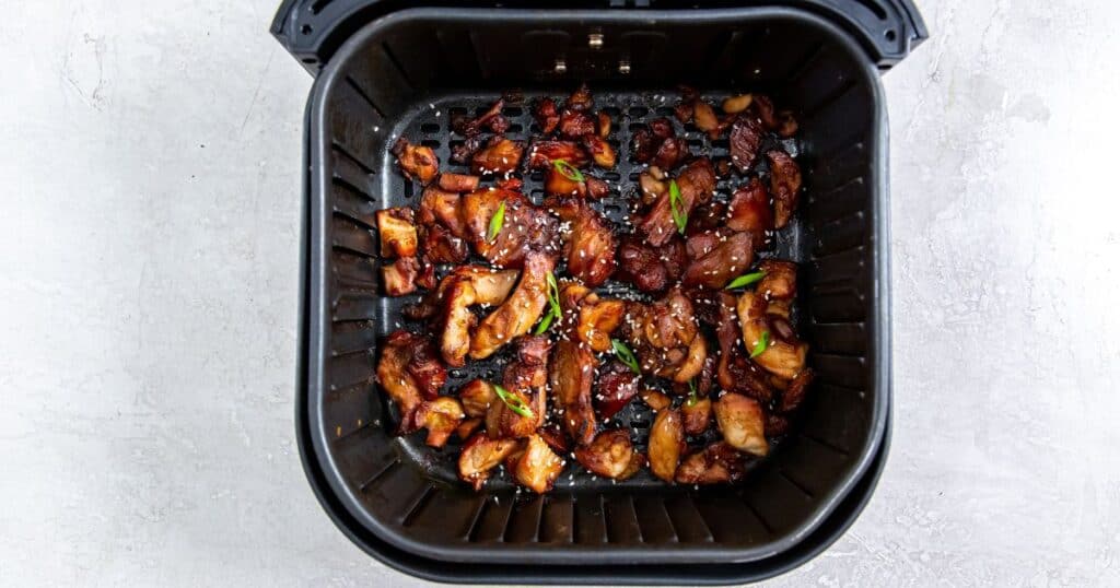 Trader Joe's Teriyaki BBA Chicken cooked in an air fryer basket.