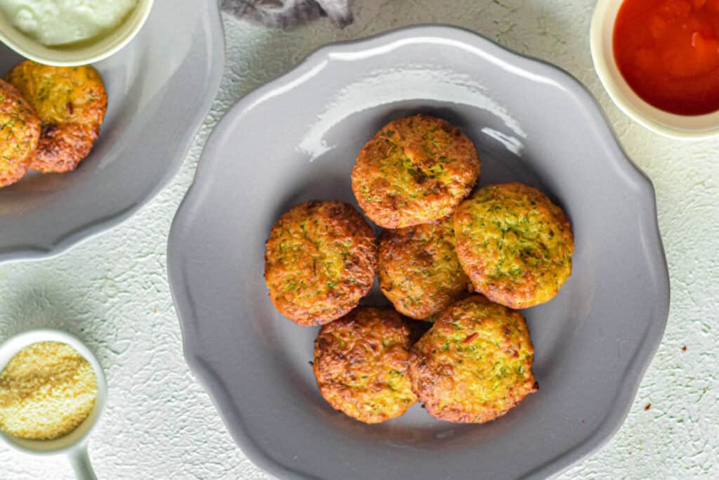 Zucchini fritters on a gray plate.