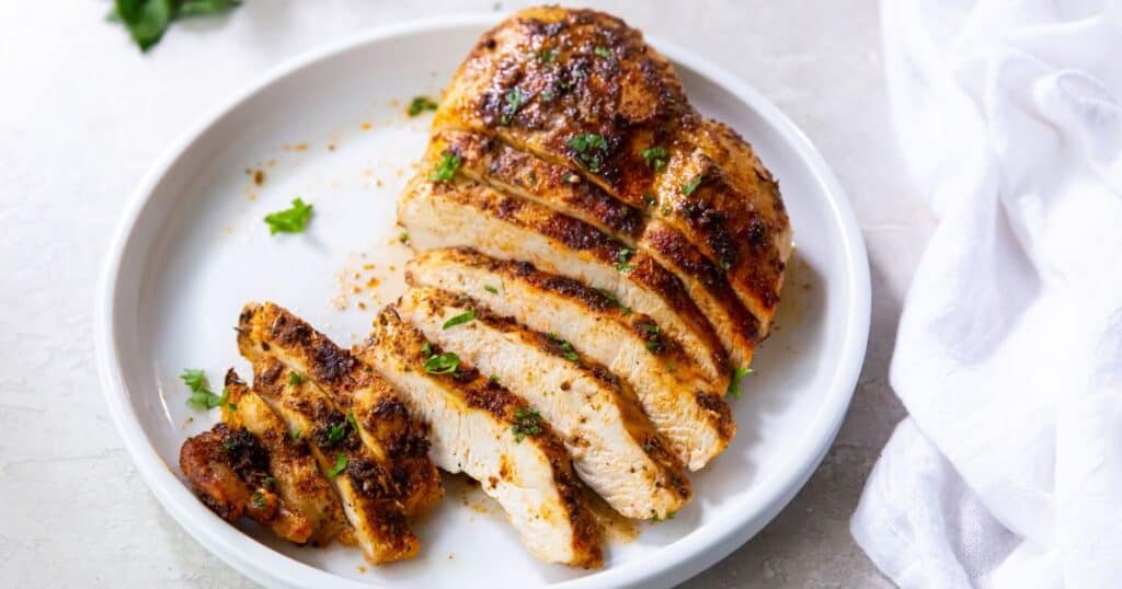 Sliced air fryer blackened chicken breast on a white plate.
