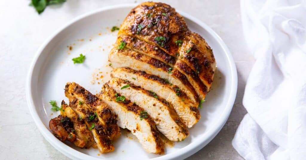 Sliced air fryer blackened chicken breast on a white plate. 