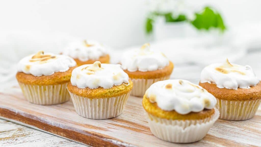 Almond Flour Cupcakes on a wooden board with meringue icing. 