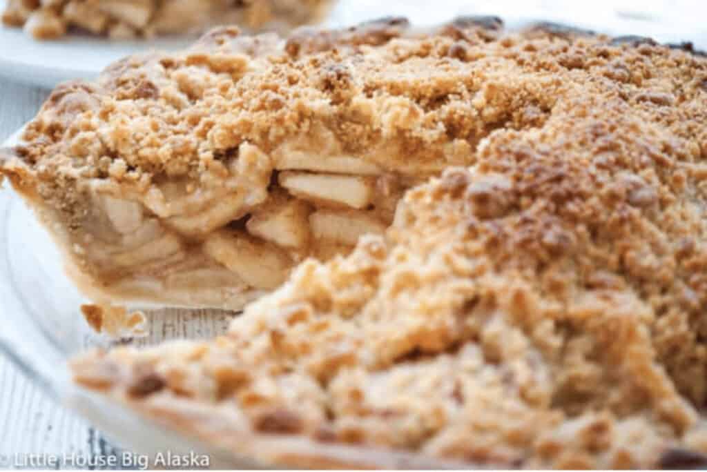 A slice of apple pie with a crumb topping.