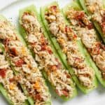 Bacon ranch chicken salad cucumber boats lined up on a plate.