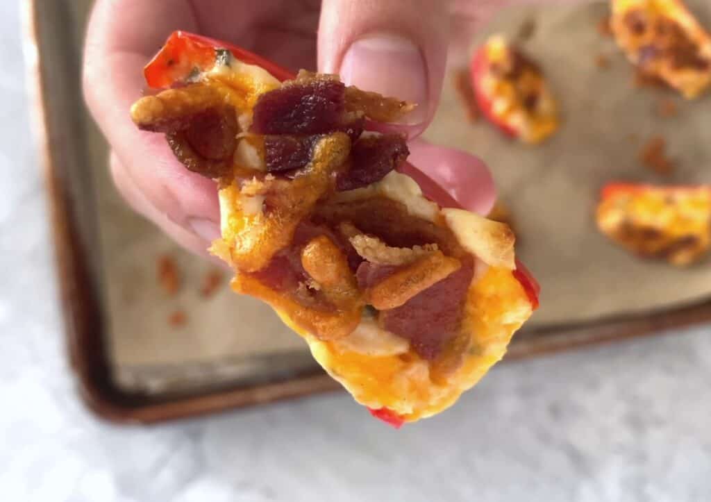 Bacon and chive mini pepper poppers being held in a hand.