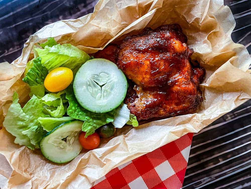 Oven BBQ chicken in a tray with a salad.