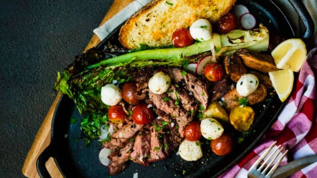 grilled bavette steak salad and grilled veg on plate.